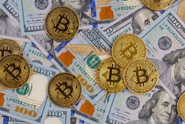 Monete bitcoin gialle sparse su banconote di carta in dollari USA criptovaluta e concetto di scambio di denaro fiat