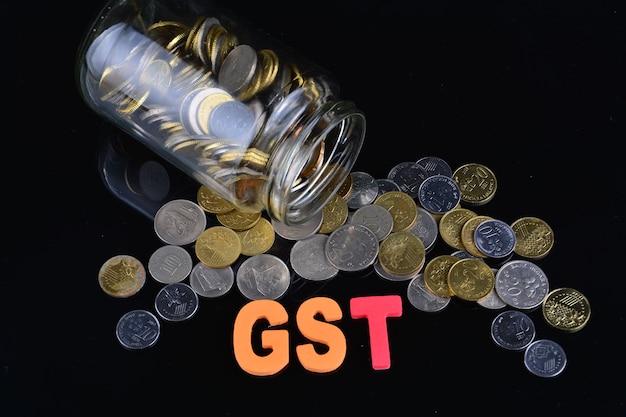 Monete che fuoriescono da un barattolo di soldi con la parola GST