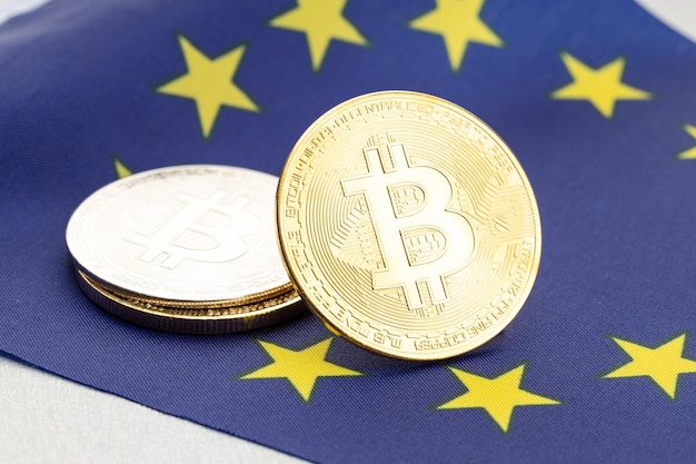 Monete di criptovaluta Bitcoin sulla bandiera nazionale dell'Unione Europea. Concetto di regolamentazione della legge crittografica