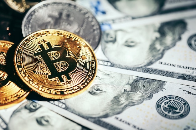 Monete dorate del bitcoin sui soldi dei dollari di carta