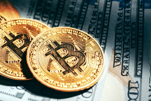 Monete dorate del bitcoin sui soldi dei dollari di carta