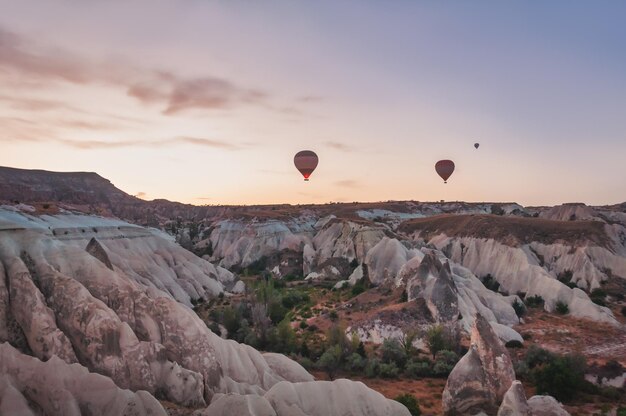 Mongolfiera al tramonto che vola la valle della montagna Siti rocciosi della Cappadocia. Goreme, Cappadocia, Turchia