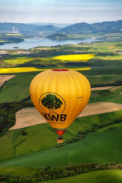 Mongolfiera gialla e bellissimi campi verdi e lago sotto nella zona di Liptov Slovacchia