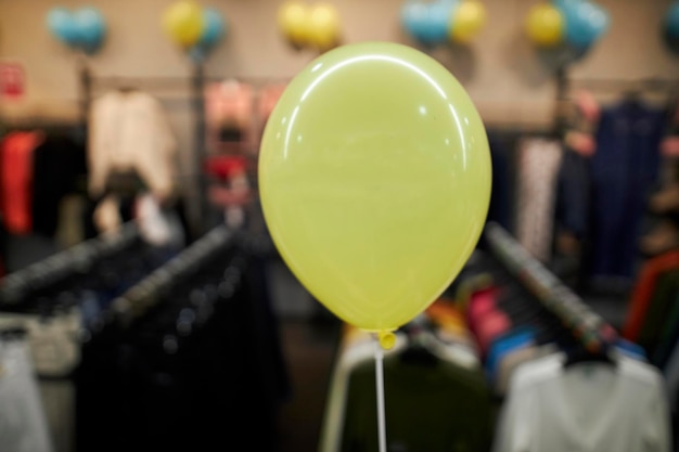 mongolfiera gialla in un negozio di abbigliamento su uno sfondo sfocato. palloncino giallo in un negozio di abbigliamento