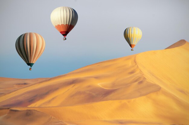 Mongolfiere colorate che sorvolano le dune di sabbia al tramonto. Africa, Namibia. Mondo della bellezza.