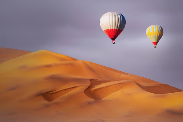 Mongolfiere colorate che sorvolano le dune di sabbia al tramonto