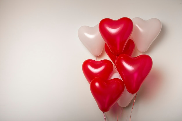 Mongolfiere. Mazzo di palloncini a forma di cuore rosso e bianco su sfondo bianco. Decorazione di San Valentino.