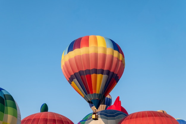 Mongolfiere variopinte che volano con il cielo blu nel festival