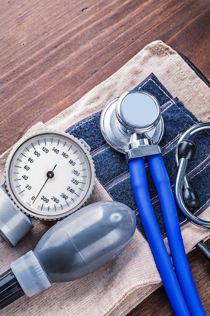 Monitor classico della pressione sanguigna e stetoscopio su tavola di legno vintage concetto medico