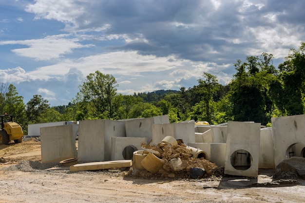 Montaggio del sistema di drenaggio, tubi di drenaggio rettangolari sul calcestruzzo nell'area residenziale della costruzione stradale urbana installata