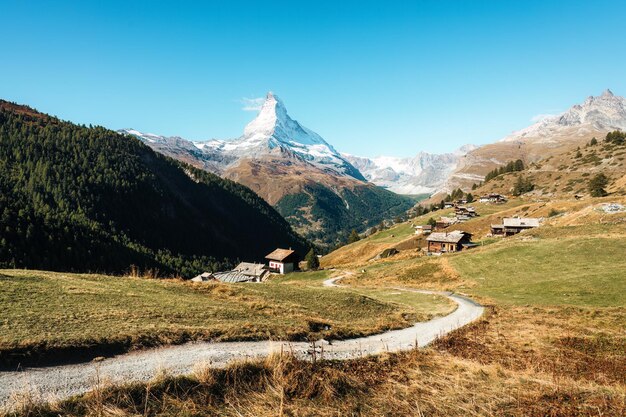 Montagna del Matterhorn con strada rurale verso il villaggio agricolo sulla collina in una giornata di sole a Findeln, in Svizzera