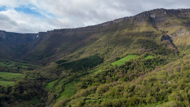 MONTAGNA DEL NORD IN ALTO CON LA FORESTA VERDE E IL VILLAGGIO NEBBIOSO