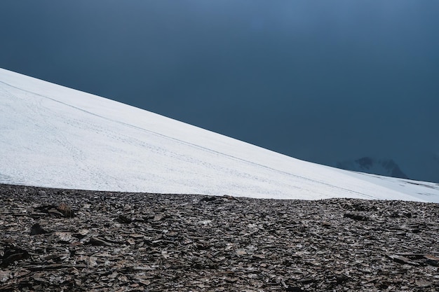 Montagna di neve e cielo blu scuro. Bellissimo paesaggio minimalista della collina di neve bianca.