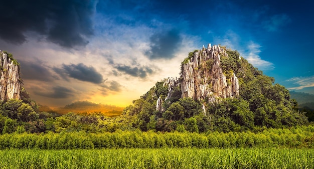 Montagna di pietra a terra agricola su sfondo tramonto