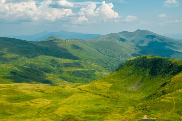 Montagna estiva. Prati e vette. Le nuvole gettano ombre