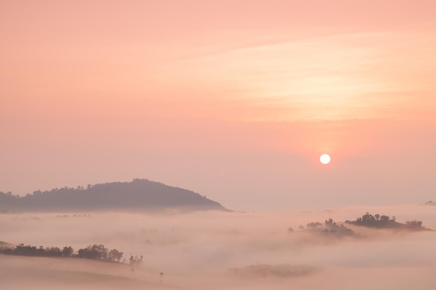 Montagne coperte di nebbia e il sole che sorge