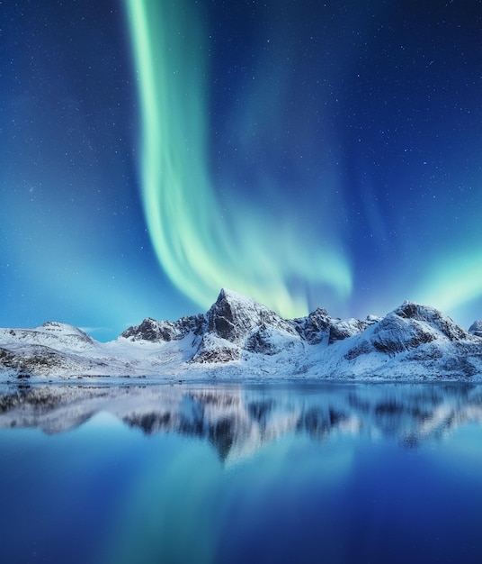 Montagne e aurora boreale nel cielo Riflessi del cielo notturno e montagne sull'acqua Paesaggio invernale in Norvegia