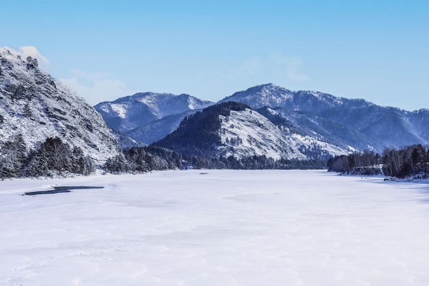 Montagne e fiume ghiacciato in inverno soleggiato