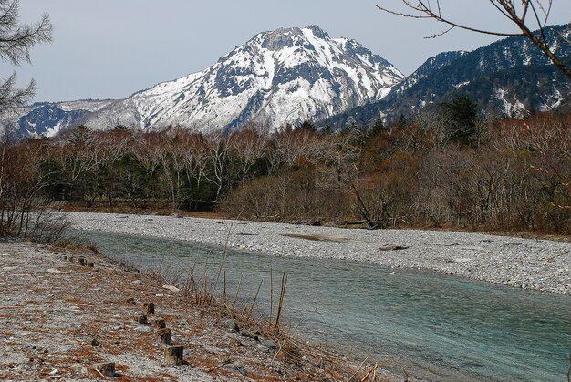 Montagne innevate sullo sfondo e lago limpido nella scena invernale a Kamikochi, Giappone