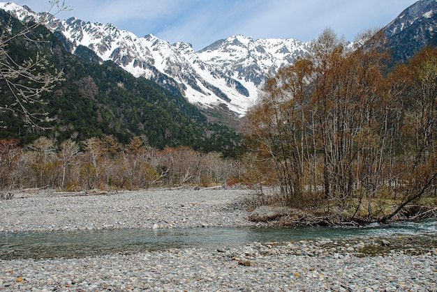 Montagne innevate sullo sfondo e lago limpido nella scena invernale a Kamikochi, Giappone