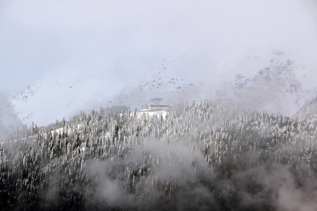 Montagne innevate tra le nuvole cielo blu Caucaso