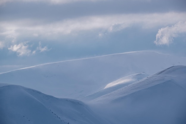 Montagne invernali innevate alla luce del sole dell'ultima sera Magnifico tramonto ventoso sulle cime sopra la pittoresca località sciistica alpina