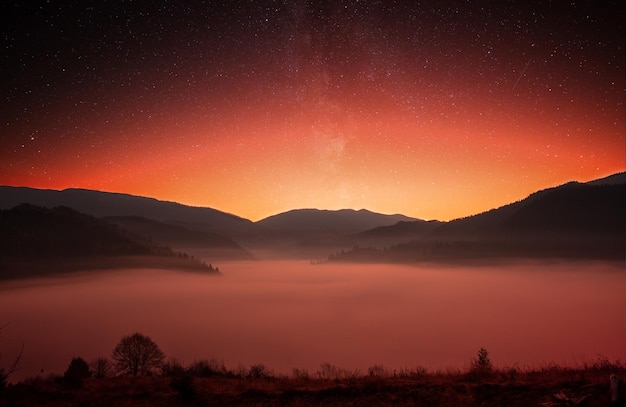 Montagne prima dell'alba Albe nel cielo e nebbia nella valle