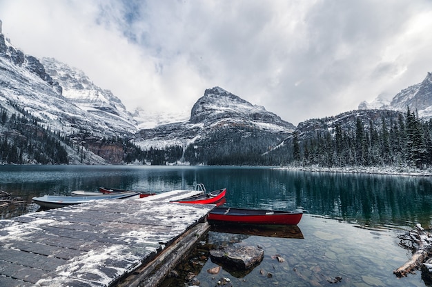 Montagne rocciose con canoa rossa al molo in legno