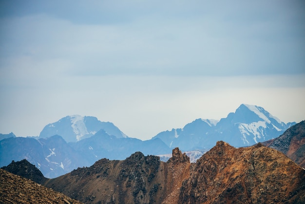 Montagne rocciose dorate e cresta di montagna innevata gigante.