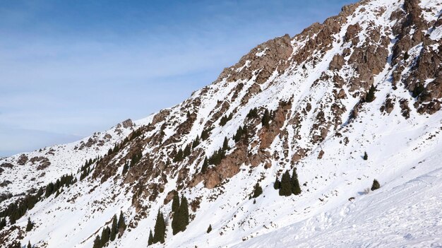 Montagne rocciose innevate contro il cielo blu