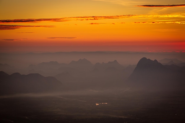 Montagne tra le nuvole all'alba in estate Veduta aerea del picco di montagna nella nebbia Bellissimo paesaggio