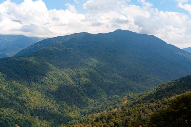 Montagne verdi sceniche e belle nuvole del cielo per lo sfondo