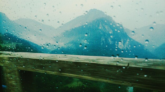 Montagne viste attraverso la finestra bagnata di un'auto