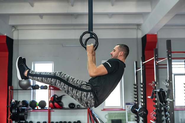 Montare il giovane caucasico che fa esercizio al concetto di sport in palestra