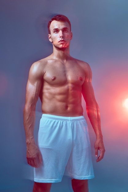 Montare l'uomo con il corpo nudo su sfondo blu con effetto motion blur muscolare sportivo alla ricerca