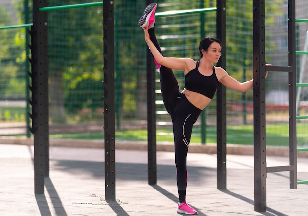 Montare la giovane donna sportiva che si esercita su una barra