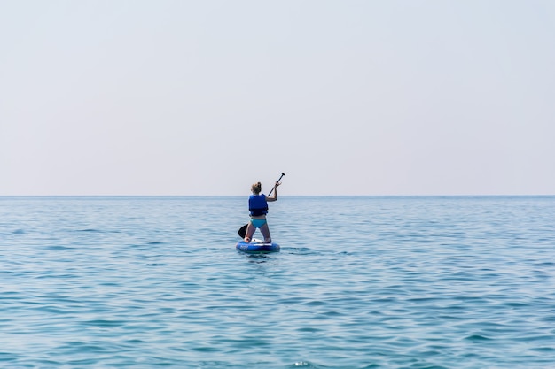 MONTENEGRO, BUDVA. i turisti sono impegnati nel canottaggio sulla tavola (SUP) sulla superficie del mare calmo.