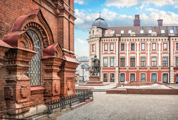 Monumento a Chaliapin vicino all'hotel e vista del livello inferiore del vecchio campanile in mattoni su Bauman Street a Kazan