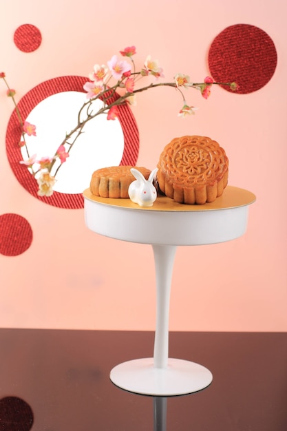 Mooncake su sfondo rosa chiaro con fiore rosa. Torta della luna di concetto sul festival di metà autunno. Mooncake Popolare come Kue Bulan.