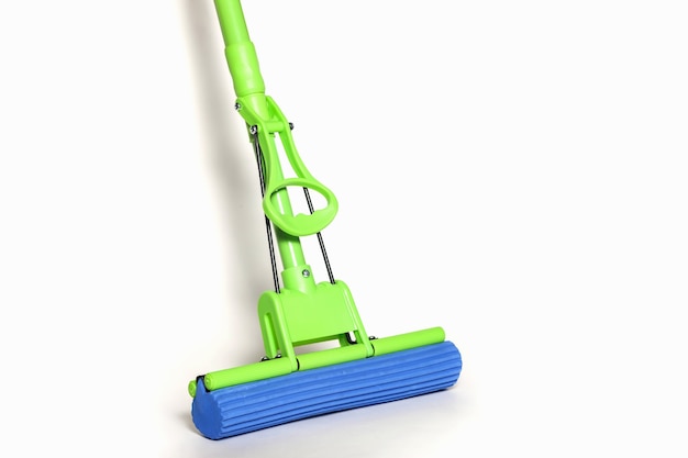 MOP verde con panno in microfibra blu isolato su sfondo bianco in primo piano. Visuale in prima persona dei mop per la pulizia della casa e del pavimento. Forniture per la casa. Concetto di pulizia per il sito. Copia spazio
