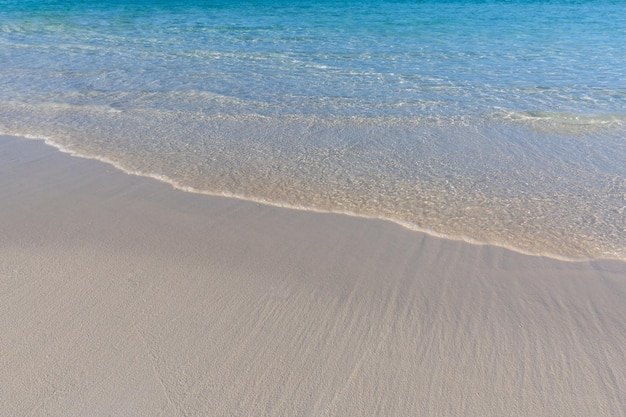 Morbida bella onda dell'oceano su sfondo spiaggia sabbiosa. Natura da spiaggia tropicale, spensierata e ispirazione