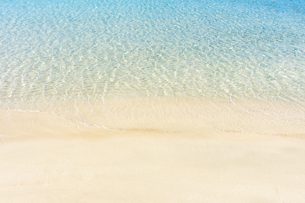 Morbida onda blu del mare sulla spiaggia sabbiosa pulita