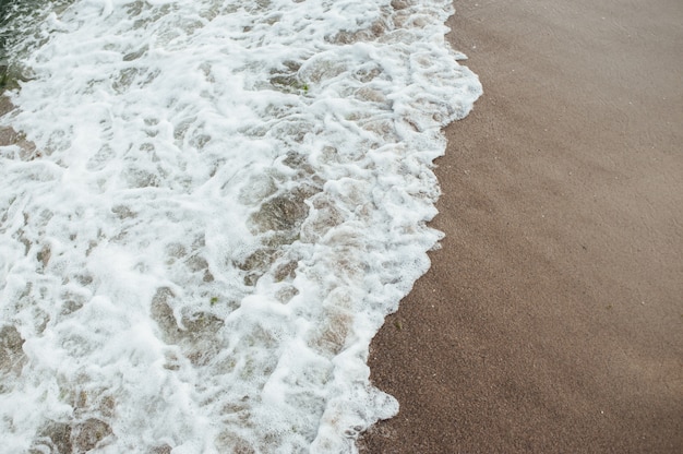 Morbida onda del mare sulla spiaggia di sabbia