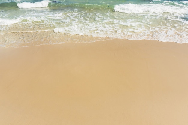 Morbida onda di mare sulla spiaggia sabbiosa vuota Sfondo con copia spazio