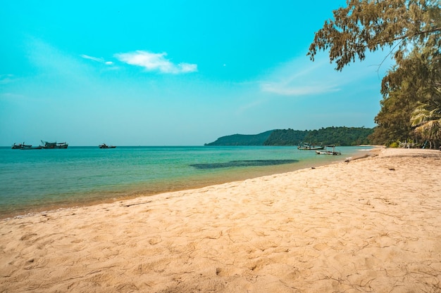 Morbide onde dell'oceano sulla lunga spiaggia di sabbia tropicale con molte impronte sulla bellissima isola di Koh Rong