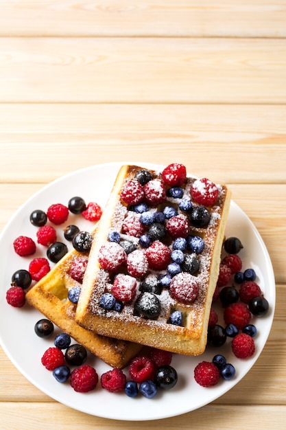 Morbidi waffle belgi con mirtilli, lamponi, ribes nero e zucchero semolato