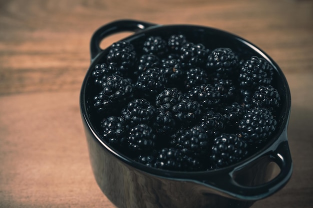 More fresche in una ciotola nera su una tavola di legno