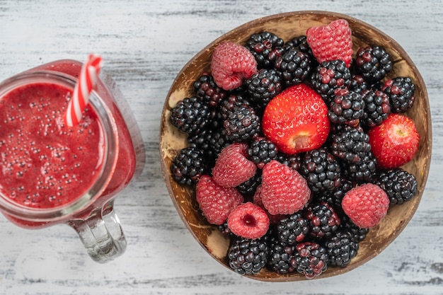 More organiche fresche, fragole e lamponi e succo in un barattolo di vetro