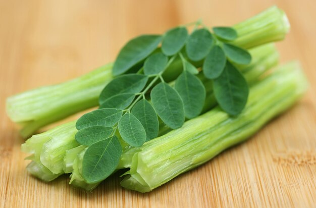 Moringa oleifera medicinale con foglie su superficie in legno