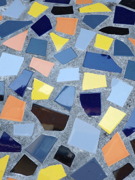Mosaico pavimentale in ceramica realizzato con tessere rotte di diversi colori Foto verticale